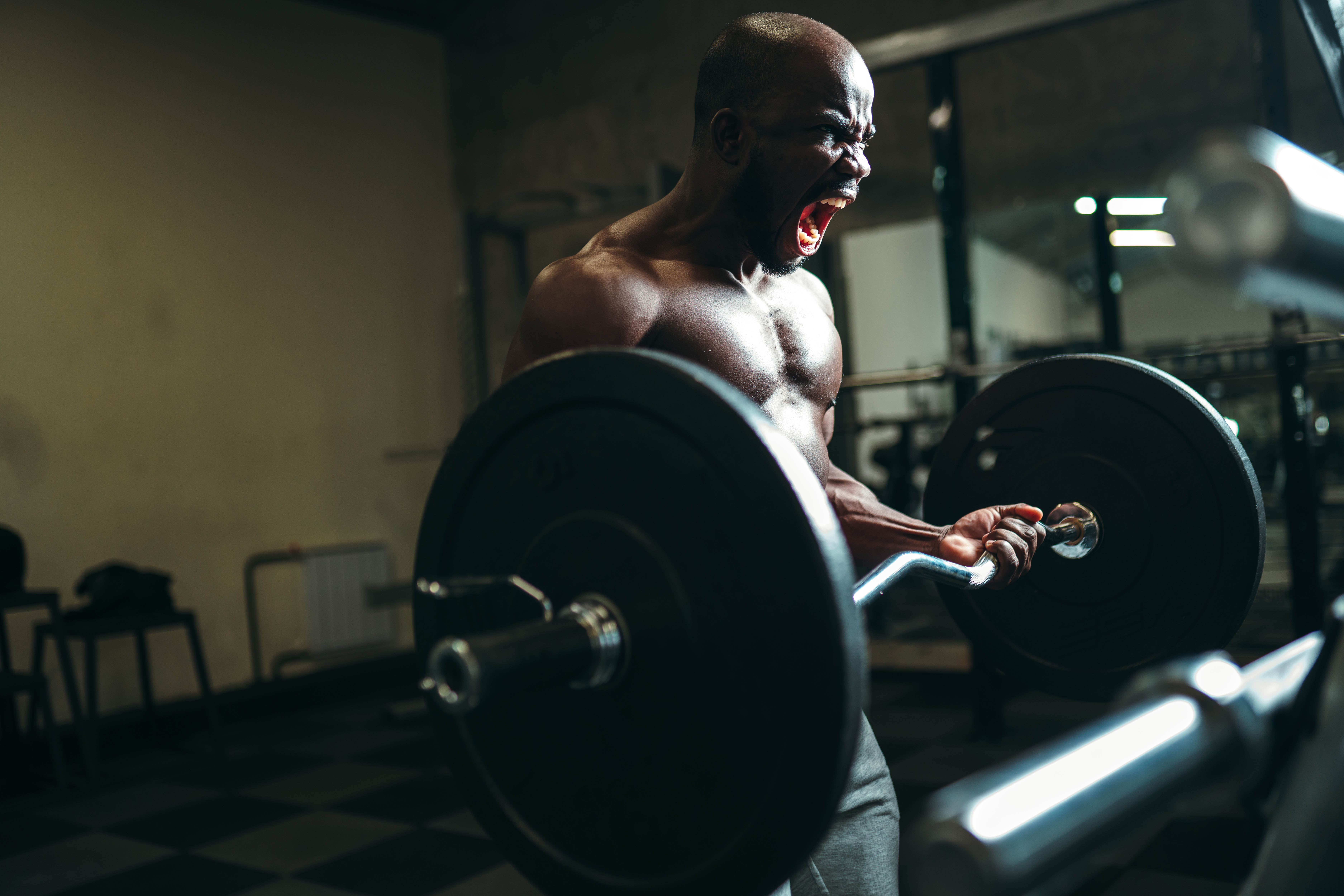 Muscular man doing a deadlift and yelling